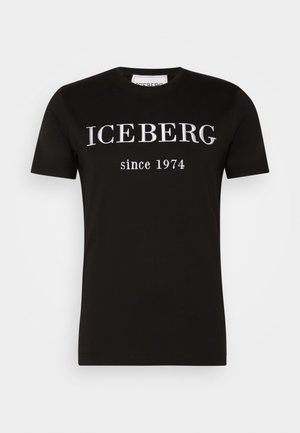 Henkilö, jolla on musta nahkatakki mustan paidan päällä, jossa lukee valkoisin kirjaimin "REBEL since 1974."