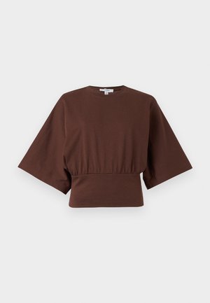 Haut court marron avec manches larges arrivant au coude et taille froncée, présenté sur un fond clair uni.