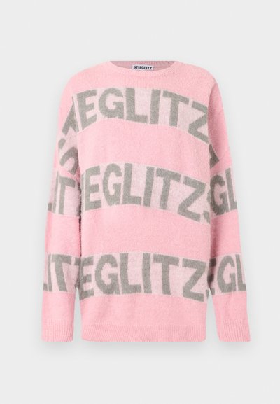 Pull rose doux à col rond avec de grands motifs de texte gris "STIEGLITZ" répétés sur le devant, les manches et la poitrine.