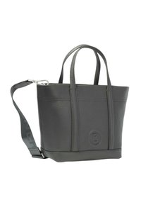 Szara torba typu tote ze skóry, z dwoma górnymi uchwytami, odpinanym paskiem i okrągłą łatką z logo po jednej stronie. Gładka tekstura, usztywniona konstrukcja.