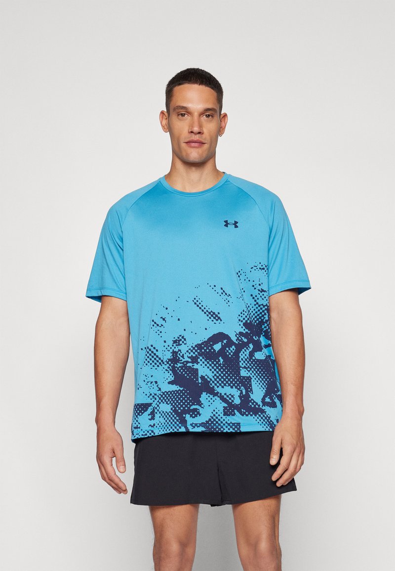 T-shirt sportivo blu realizzato in tessuto leggero. Presenta un design a gradiente con motivi a macchie blu scuro. Collo rotondo e maniche corte.