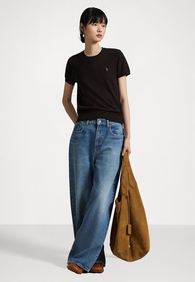 Črna majica s kratkimi rokavi, modri široki jeans s raztrganim robom, rjava semiš torba. Minimalističen dizajn z diskretno blagovno znamko.