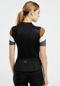 Maglia da ciclismo nera con spalle in stampa leopardata, maniche corte e vita elastica. Tessuto testurizzato con un design aderente.