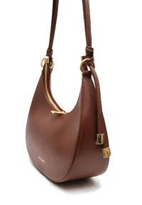 Sac à main en cuir marron avec une forme courbée, accents en matériel doré et fermeture zippée. Présente une texture lisse et une bandoulière réglable.