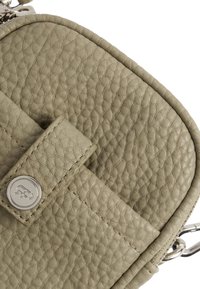 Borsa in pelle texturizzata verde chiaro con forma arrotondata, dotata di un pulsante in metallo argentato ben visibile e di una tracolla per indossarla a croce.
