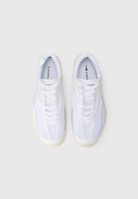 Sneakers bianchi in mesh con dettagli lisci. Presentano una punta rotonda e una suola testurizzata, con chiusura a lacci e dettaglio del logo.