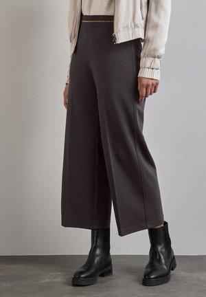 Wide-leg, dark gray pants made of soft fabric, featuring a smooth texture and elastic waistband, paired with black ankle boots.