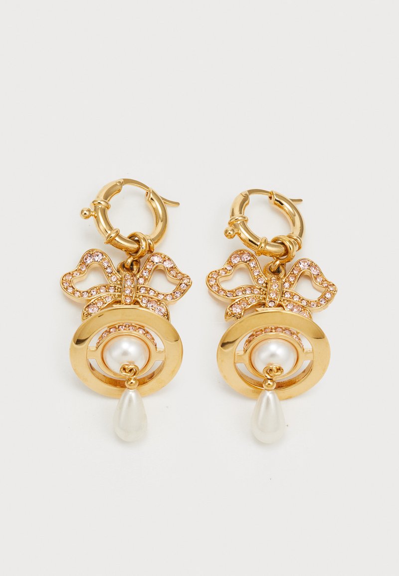 Zelta riņķa auskari ar sirds formas loku, kuru rotā rozā rhinestones. Iekļauj centrālo pērli un karājošu bumbiera formas akcentu.