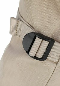 Tissu de sac à dos beige avec une surface texturée, présentant une boucle en plastique noir et des détails de sangle. Un angle en gros plan met en avant la qualité du matériau.