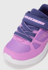 Paarse en roze Skechers sneaker met marineblauwe veters en klittenbandsluiting, witte zool en "S"-logo op het zijpaneel.