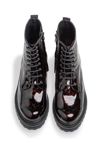 Stivaletti alla caviglia in pelle patinata nera con finitura ad alta lucentezza, dotati di una chiusura con lacci frontale, zip laterale e suola in gomma spessa.