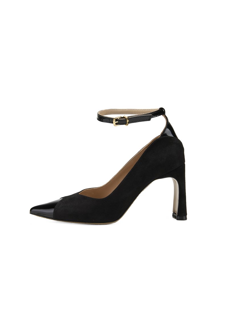 Escarpin noir en suède avec un bout pointu noir brillant, une bride à la cheville avec une boucle dorée et un talon transparent. Texture lisse dans l'ensemble.