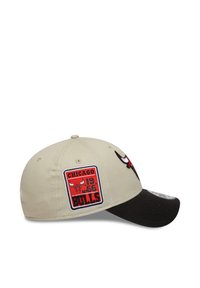 Gorra de béisbol beige con visera negra, que presenta un logo bordado en rojo y blanco de los Chicago Bulls y un parche con la fecha de establecimiento en el lado.