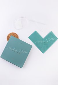 Teal-kotelo kultakirjaimin, jossa on teksti "fresh is Better", kahden teal-vihkon, kirkkaan levyn ja pillin kanssa. Mukana myös kudottu alusta.