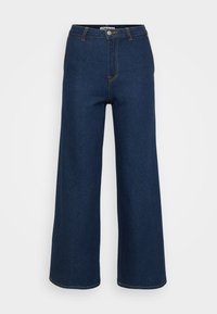 Weite Jeanshose in Dunkelblau mit kontrastierenden gelben Nähten, hoher Taille und Knopfverschluss. Glatte Textur und klassisches Design.