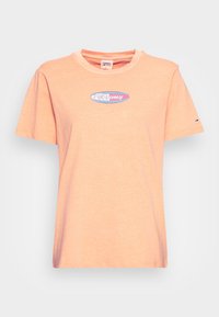 Ljusorange bomullströja med rund halsringning och korta ärmar. Har en färgglad "Tommy"-logotyp i oval design på framsidan.