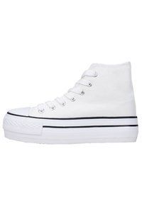 Sneaker alte bianche in materiale canvas, suola piatta in gomma bianca, dettaglio a striscia nera, punta rotonda e design con lacci a più occhielli.