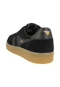 Black suede sneaker with a textured upper, grey leather accents, gum rubber sole, and gold logo detail on the heel. Classic design.