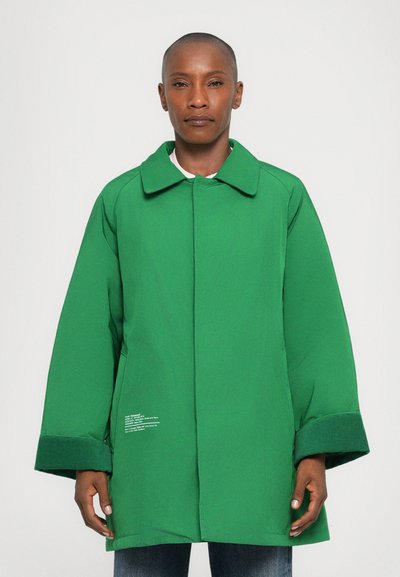 Cappotto verde con colletto strutturato, maniche ampie e taglio dritto. Presenta un tessuto texturizzato e dettagli in bianco sull'orlo.