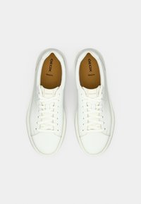 Λευκά δερμάτινα αθλητικά παπούτσια με στρογγυλή μύτη, επίπεδη σόλα και σχέδιο με κορδόνια. Διαθέτουν σήμανση "GEOX Respira" στις εσωτερικές σόλες. Ομαλή υφή, με ελάχιστες λεπτομέρειες.