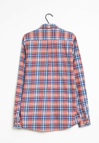 Koszula w kratę z długim rękawem, w czerwone, niebieskie i białe wzory, z kołnierzykiem zapinanym na guziki i lekką tkaniną. Wisi na czarnym wieszaku.