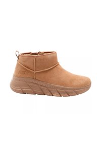 Stivaletti alla caviglia in suede beige con profilo basso, punta tonda e suola leggera e testurizzata. Presentano una linguetta per un facile indossamento e dettagli di cucitura ridotti.