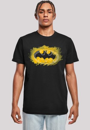 Black t-shirt with short sleeves featuring a vibrant yellow Batman logo surrounded by a textured splatter design.