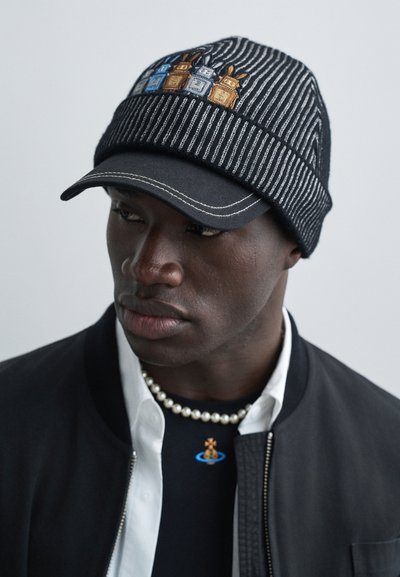 Casquette rayée noire et blanche avec un sommet arrondi, ornée de lanternes colorées brodées. Elle possède une visière plate et une bande tricotée texturée.