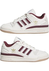 Witte leren sneakers met bordeauxrode accenten, met een ontwerp van drie strepen, gevoerde kraag en rubberen zool. Gouden logo aan de buitenzijde.