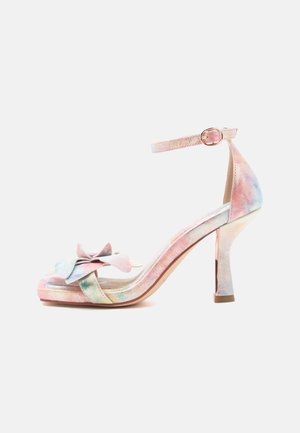 Sandale à talon haut à bout ouvert avec bride à la cheville et détail nœud, présentant un motif tie-dye pastel dans des nuances de rose, bleu et vert.