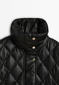 Czarna pikowana kurtka puchowa z wysokim kołnierzem i trzema matowymi srebrnymi napami na przedniej listwie.