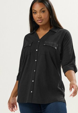Zwarte lange mouw shirt met een kraaghals, twee borstzakken en een knoopsluiting aan de voorkant. Glad materiaal met een relaxte pasvorm.