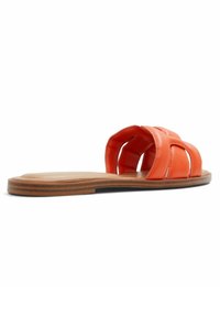 Sandale en cuir orange à glisser avec un design de straps croisées, semelle plate marron et texture lisse. Style ouvert à l'avant pour un enfilage facile.