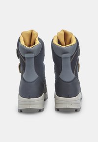 Botas impermeables de color azul oscuro con detalles en gris y forro amarillo. Cuentan con talón reforzado y correas ajustables para un ajuste seguro.