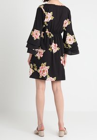 Černé květinové šaty s růžovými růžemi, rozšířenými rukávy a elastickým pasem. Mají délku ke kolenům a lehkou látku.