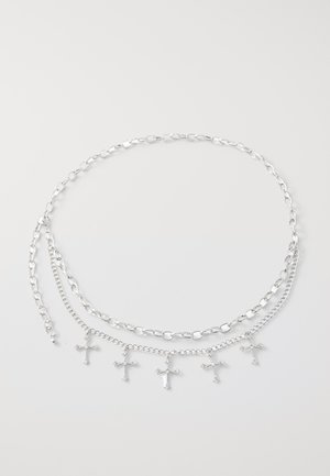 Collier en argent composé de trois chaînes superposées et de cinq petits charms en forme de croix. Les maillons sont ovales et arrondis, avec une finition polie.