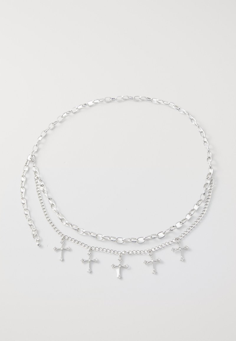 Silver chain necklace featuring three layered chains and five small cross charms. The links are oval and rounded, with a polished finish.