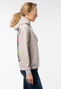Lichtgrijze hoodie met een voorvak, grafische print en verstelbare trekkoorden. Beschikt over ribgebreide manchetten en zoom, met een label op de mouw.