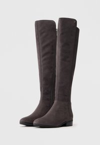 Botas de camurça cinza até ao joelho com saltos baixos em bloco e fecho lateral, lado a lado sobre um fundo branco.