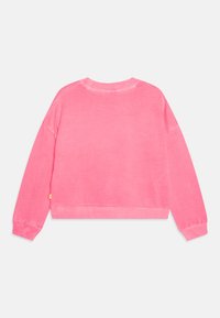 Felpa rosa con vestibilità rilassata, colletto a girocollo a costine e maniche lunghe, con orlo leggermente corto e un'etichetta sul lato sinistro.