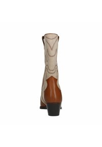 Botte ankle en cuir marron avec dessus en tissu beige, ornée de coutures décoratives en motif de vague et dotée d'un talon bas.