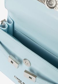 Lichtblauwe gestructureerde handtas met een gladde textuur, voorzien van zilverkleurige hardware, dubbele compartimenten en een magnetische drukknoopsluiting.