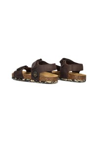 Brune leren sandalen met verstelbare banden, kurken voetbed en een geprofileerde rubberen zool. Heeft een knoopdetail aan de zijkant.