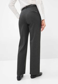 Charcoal grijze wijde broek met een gladde textuur, een achterzak en een zwarte riem, gestyled met een wit shirt.