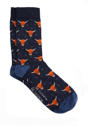Marineblauwe sokken met blauwe hakken en tenen, versierd met herhalende oranje stierenkoppen en kleine abstracte vormen.