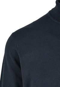 Strikket høyhalsergenser i mørk marineblå, med en jevn tekstur og tettsittende design. Uthevet med en ribbestrikket krage.