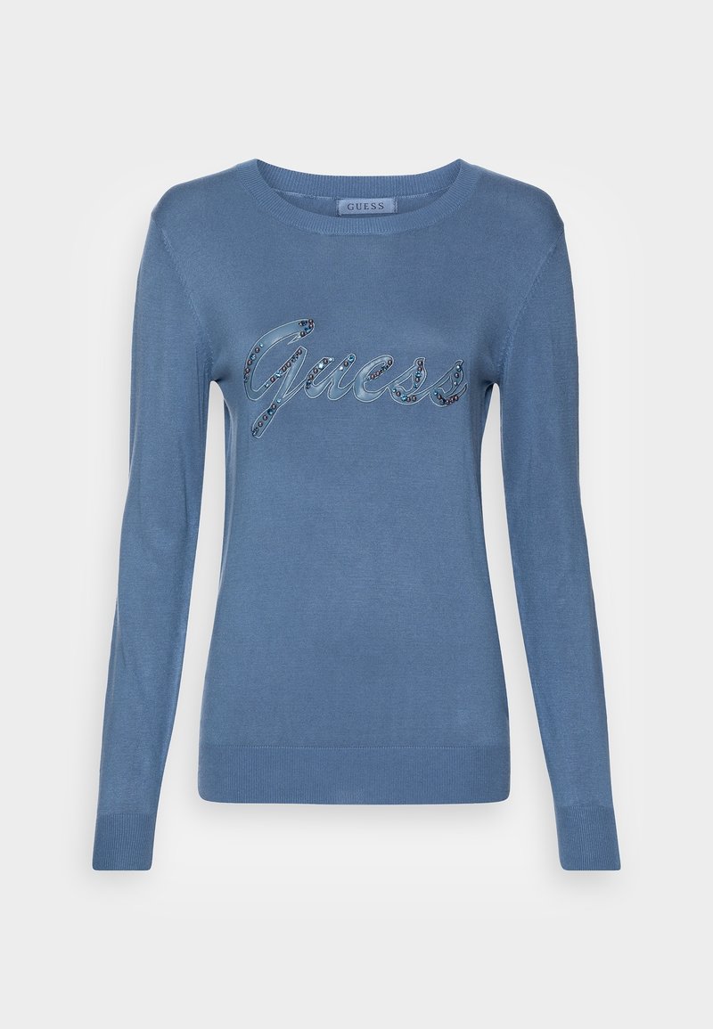 Lichtblauwe gebreide trui met lange mouwen, geribbelde manchetten en een ronde halslijn. Heeft een decoratieve "Guess"-logo versierd met edelstenen.