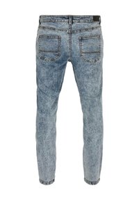 Jean en denim bleu clair avec une coupe slim, doté de deux poches arrière, de coutures renforcées et d'une texture légèrement décolorée.