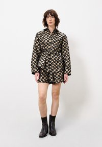 Luipaardprint, knoopjesoverhemd jurk met een riem, met lange mouwen en een afgeronde zoom. Gеdrgen met slanke zwarte enkellaarsjes.