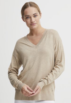 Beige, lett V-hals genser med lange ermer, ribbede mansjetter og hem, har en subtil tekstur og en logo aksent på siden.